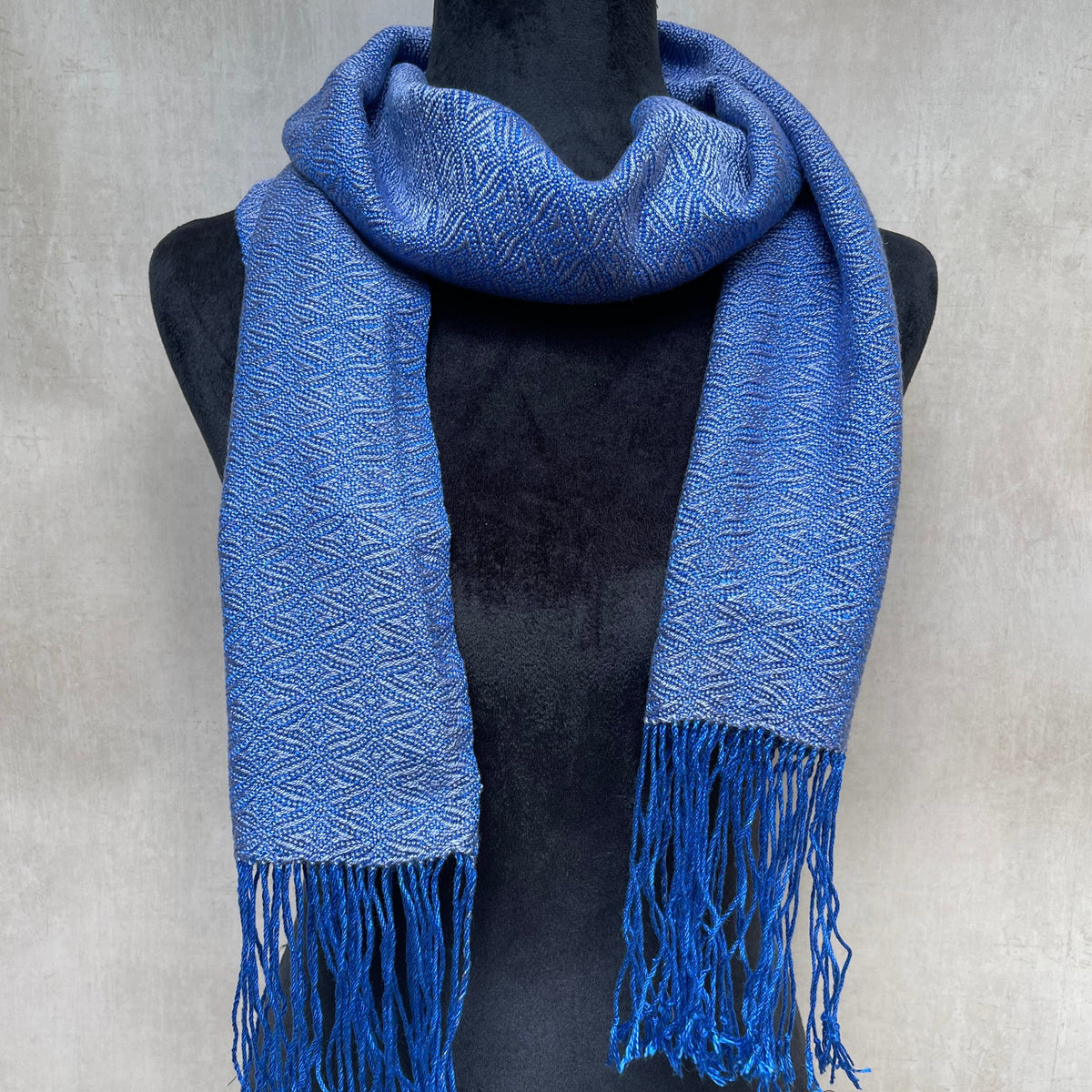 Bluberry color tencel scarf with fringes on a light gray background
